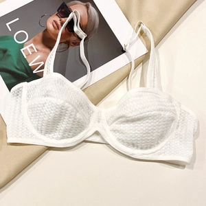 Close-up of white lace bra featuring delicate floral texture on stylish background