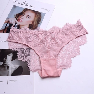 Detailed close-up of rose pink lace panties with floral embroidery and eyelash trim texture
