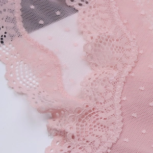 Detailed view of pink floral lace and polka dot mesh texture on low-rise panties