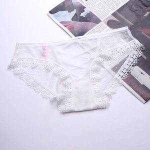 Dettaglio di mutandine in mesh bianco con design incrociato e delicati ricami in pizzo