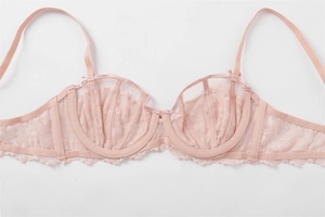 Detailed macro view of light pink floral lace embroidery and fine mesh on bra cups