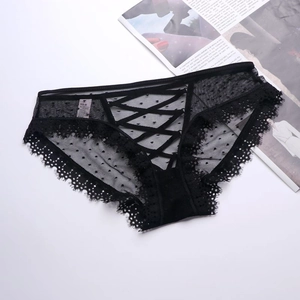 Dettagli dello slip in pizzo nero con mesh trasparente e decorazione a pois floccati