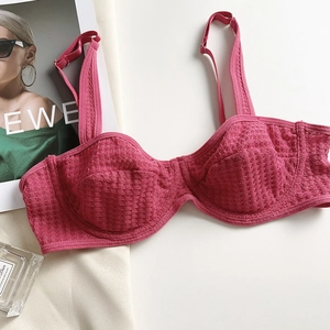 Detail of rose red mesh lace balconette bra styled with a fashion magazine and perfume