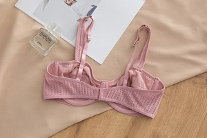 Detail view of breathable lace mesh bra in pink with adjustable straps and back closure