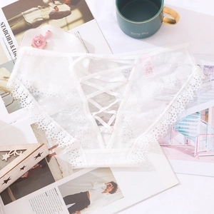Dettaglio slip in pizzo bianco con rete traspirante e lacci decorativi sul retro