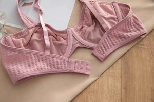 Detail of the pale pink lace bra showing three-row hook closure and adjustable straps