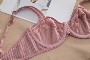 Close-up of pink lace mesh bra showing intricate embroidery and breathable honeycomb fabric