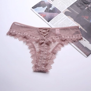 Vue détaillée du string en tulle rose poudré avec dentelle délicate et laçage à l'avant