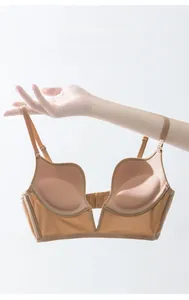 Detail of a beige seamless deep V-neck bra with fixed cups and glossy side fabric