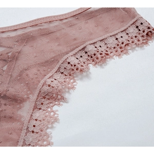 Détail macro du tissu en maille respirant et dentelle florale sur la lingerie