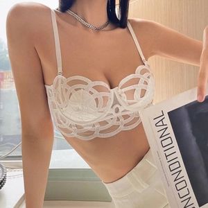 Détail d'un soutien-gorge en dentelle blanche avec motifs géométriques et bretelles