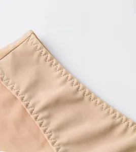 Detail of nude seamless bra waistband with elastic zigzag stitching and knit texture
