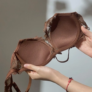 Detail of deep brown lace bra showing intricate floral embroidery and soft cup lining texture