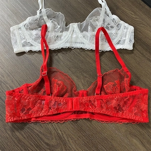 Detail of floral lace embroidery and mesh fabric on these white and red bras