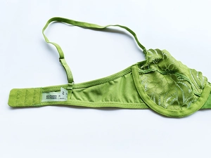 Detail of green lace bra showing 90% polyester fabric texture and adjustable straps