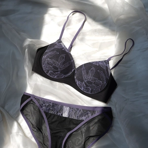 Ensemble de lingerie en dentelle florale violette et mesh noir sur tissu de soie blanc