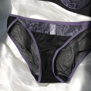Détails de dentelle florale violette et maille noire sur une culotte respirante sexy
