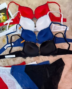Flat lay of lace lingerie sets with leopard print trim in red, white, blue, and black