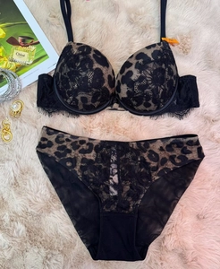 Flat lay of leopard print lace lingerie set with bra and panties on beige carpet
