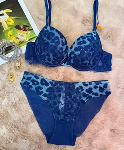 Detail of leopard print lace lingerie set with 75C size tag on a pink furry background