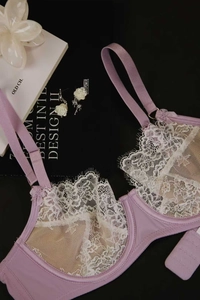 Detail view of lavender lace bra with white floral embroidery and satin bow accents