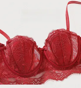 Gros plan sur la dentelle florale rouge du soutien-gorge demi-bonnet avec petit nœud