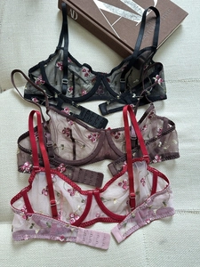 Detailed embroidery on sheer floral lace bras in black, brown, and pink colors
