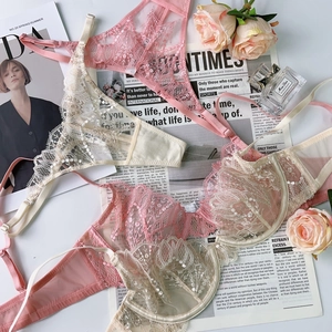 Flat lay of pink and white lace lingerie set with floral patterns and luxury props