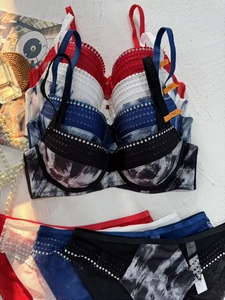 Flat lay of lace lingerie sets with rhinestone accents and ink prints in various colors