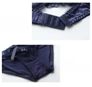 Detail of dark blue lace lingerie set featuring metal back hooks and a delicate bow detail