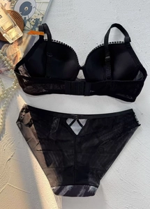Detailed flat lay of black mesh lingerie set with lace straps and sheer back details