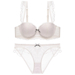 Detailed shot of white lace bra set with ruffle straps and tiny bowknot detail