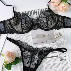 Vue détaillée d'un ensemble de lingerie en dentelle noire avec parfum et roses décor
