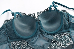 Detailed close-up of dark green lace bodysuit featuring cup padding and mesh texture