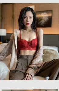 Détail d'un soutien-gorge en dentelle rouge avec bretelles sous une chemise en soie