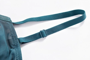 Detailed close-up of adjustable straps and sheer mesh lace on a teal bodysuit