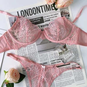 Détail de la broderie en dentelle florale rose et du mesh transparent de l'ensemble