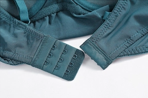 Detail of teal lace bodysuit featuring three-row hook and eye closure for adjustment