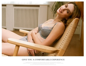 Detailed view of sexy grey lace lingerie set with elegant scalloped edges on a rattan chair