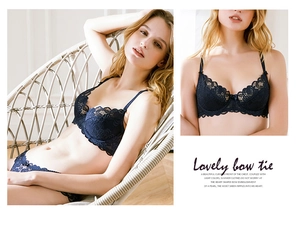 Detail of dark blue lace bra set with delicate bow tie and scalloped embroidery trim