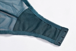 Detail of dark green lace bodysuit showing breathable mesh fabric and hook-and-eye closure