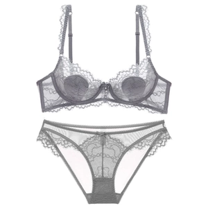 Set di lingerie in pizzo grigio con reggiseno e slip abbinati su sfondo bianco