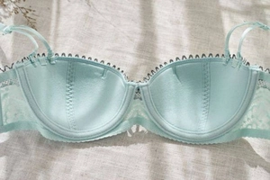 Detailed macro of mint green lace bra interior showing wire support and mesh texture