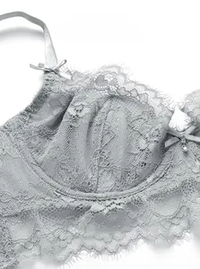 Nahaufnahme von silbernem Spitzen-BH mit zarten Wimpernspitzen und Strass-Anhänger-Detail