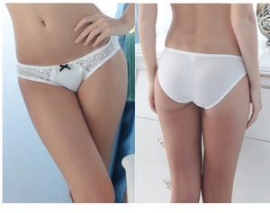 Détail de culotte en dentelle blanche avec nœud noir et broderie florale pour femme