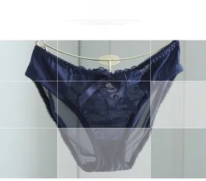 Detail of dark blue lace panties with sheer mesh and floral embroidery texture