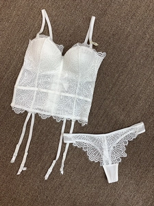 Vue détaillée d'un bustier en dentelle blanche et string avec étiquette 75B sur tapis