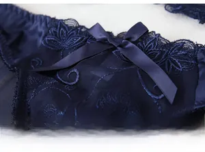 Detail of midnight blue lace panties with floral embroidery and satin bow decoration