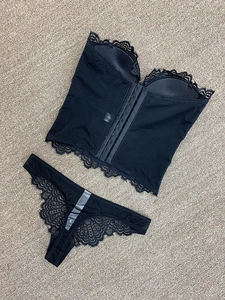 Détail de la fermeture à crochets multi-rangs au dos du body et du string en dentelle noire