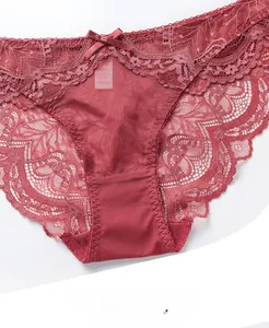 Detail of burgundy lace underwear featuring floral patterns and a small satin bow tie
